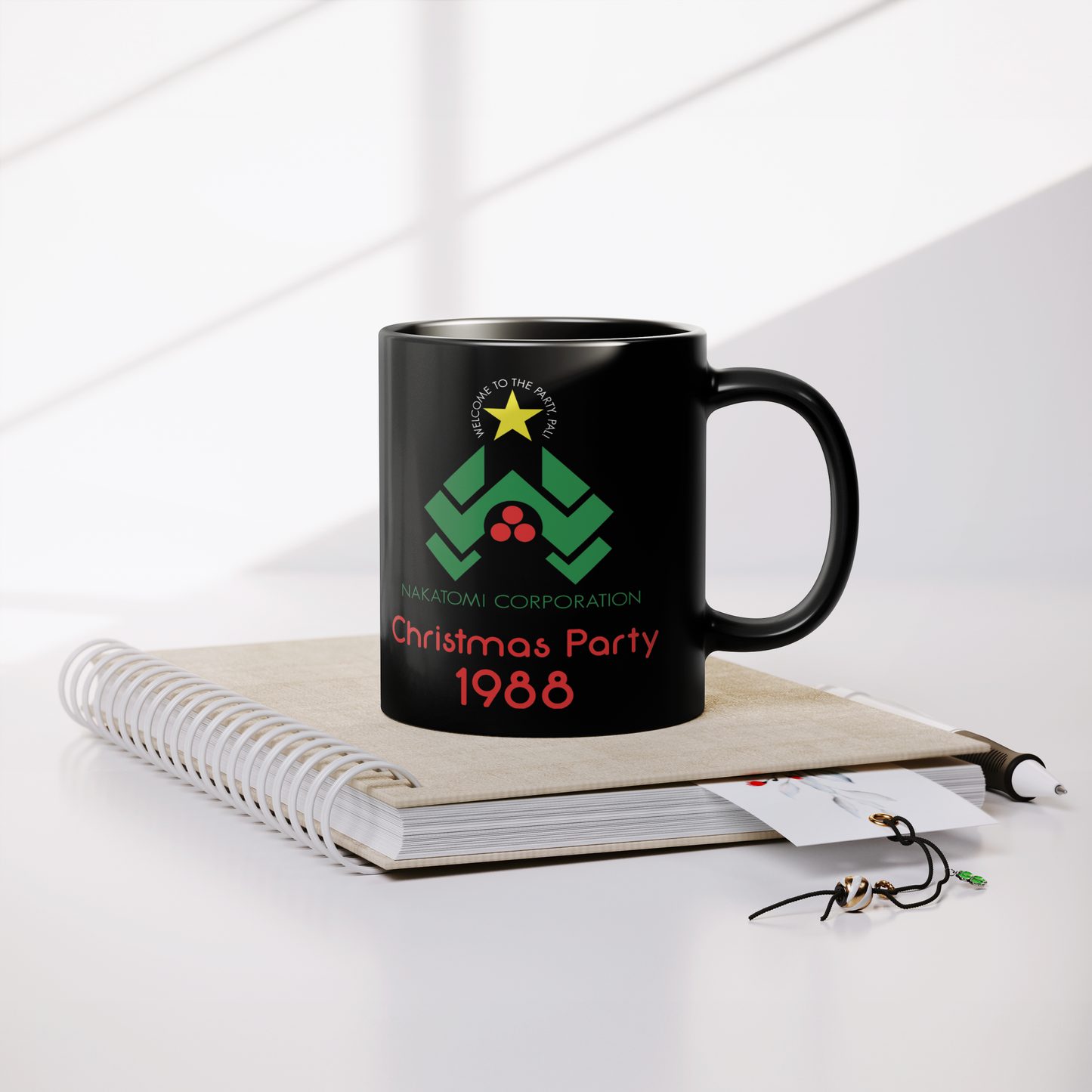 Nakatomi_Christmas_Party_-_11oz_Mug_Lifestyle_Notebook_Mockup.png
